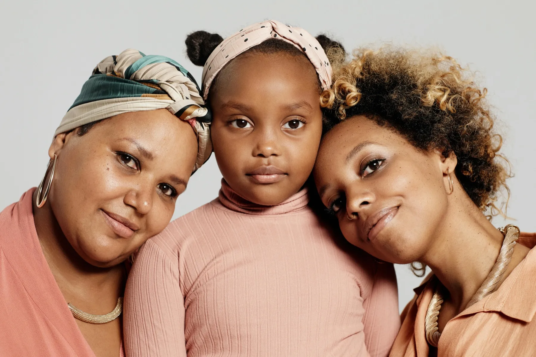 Two women and a young girl posed cheek to cheek